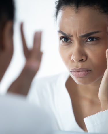 Woman examining expression lines before a neuromodulator consultation